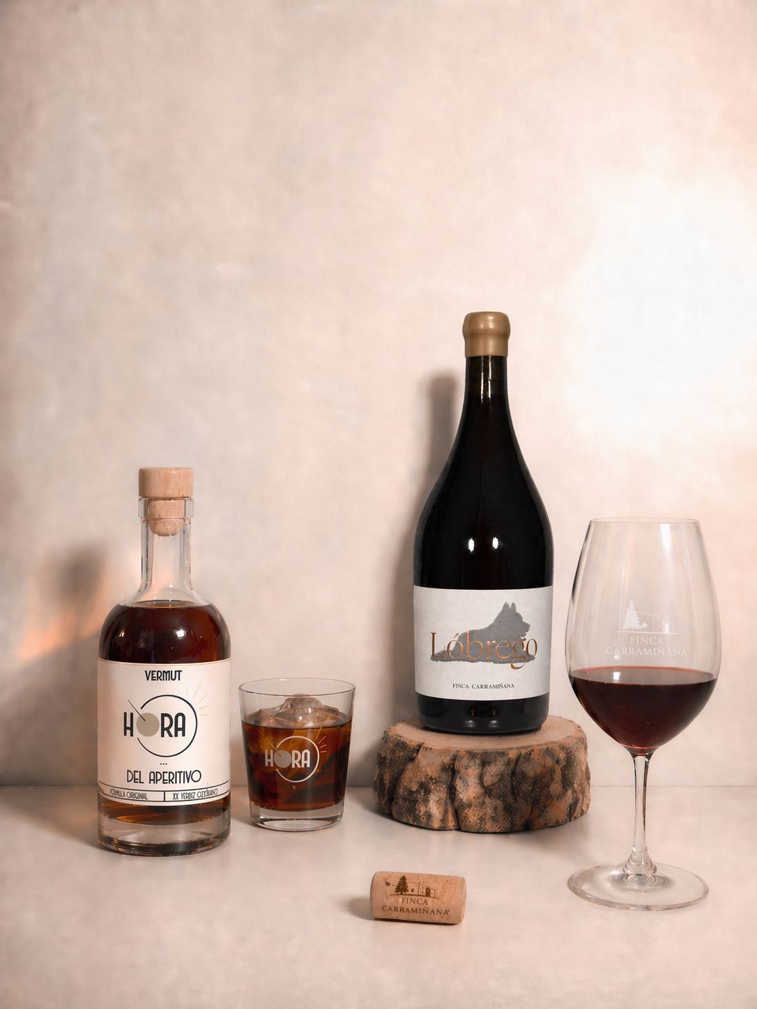 Botella de Lóbrego y botella de Hora juntas con copa de vino y vaso de vermut